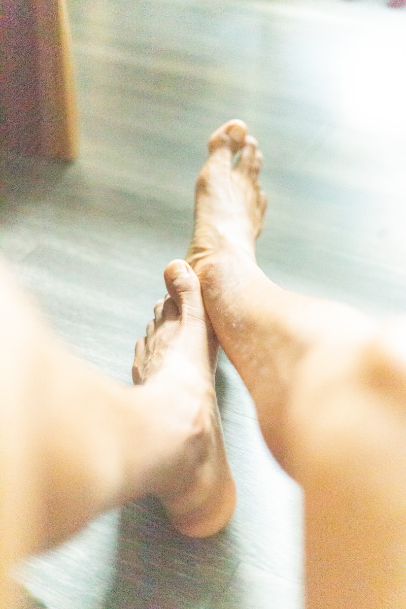 a close up of a person's bare feet on a wooden floor