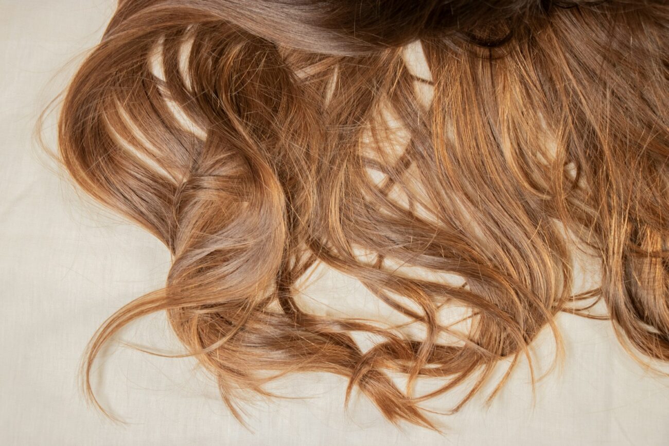 a close up of a woman's hair laying on a bed