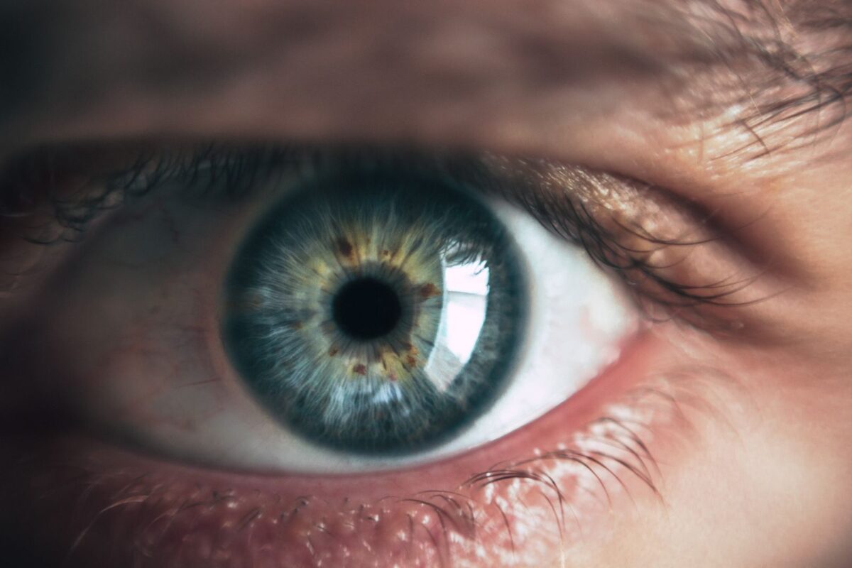 A close-up of a healthy human eye with a blue-green iris