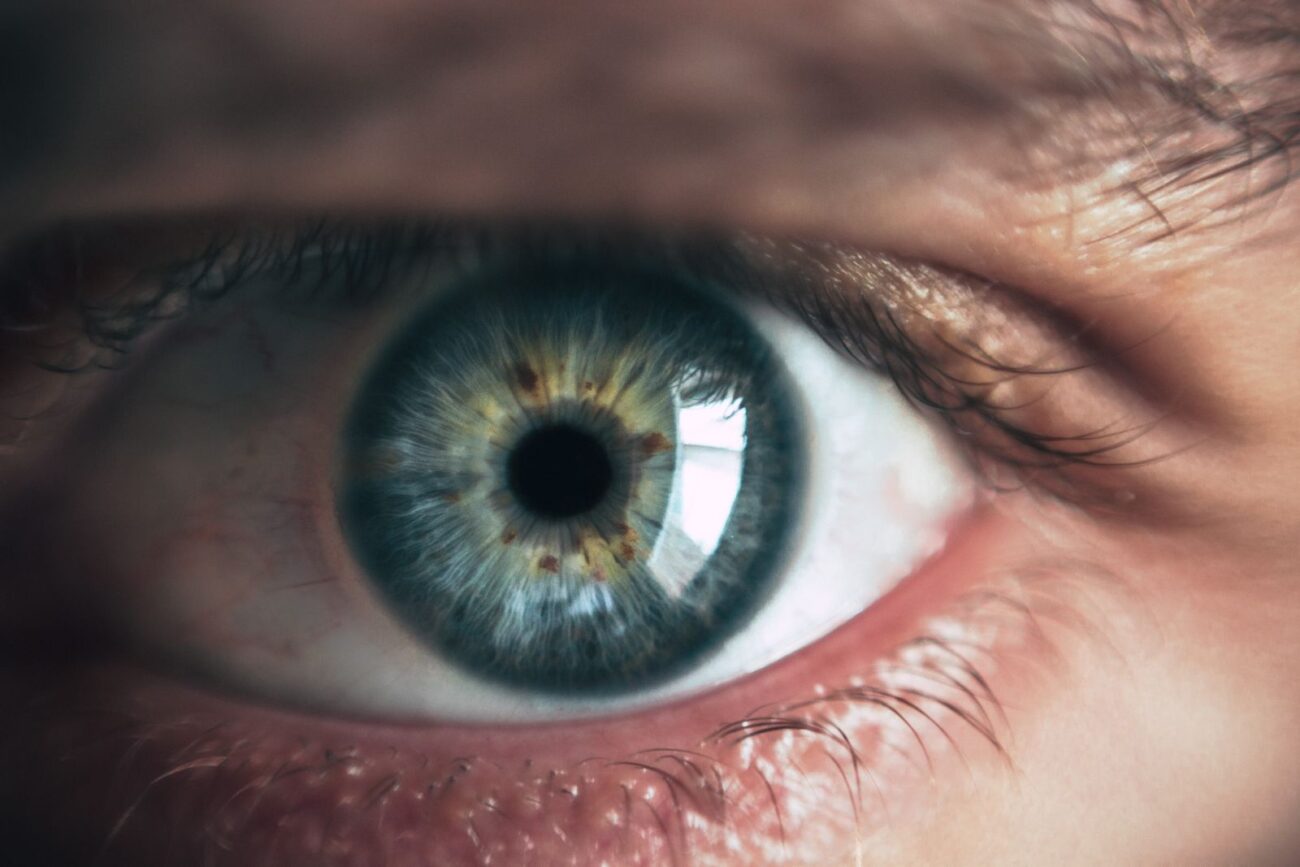 A close-up of a healthy human eye with a blue-green iris